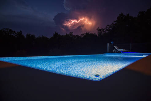 Beleuchtetes Schwimmbad mit nächtlichem Gewitter - MAMF02895