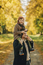 Glücklicher Vater und Sohn haben Spaß im Herbstpark - VSNF01419