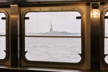 Freiheitsstatue durch das Fenster der Staten Island Ferry im Hudson River gesehen - MMPF00999