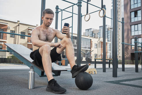 Man using fitness tracker on smart watch at gym - MRPF00012