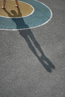 Schatten eines Mannes, der auf einem Sportplatz einen Handstand macht - MRPF00014