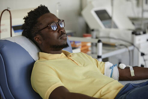 Mann mit Brille beim Blutspenden - KPEF00296