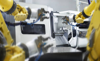 Gelbe Roboterarme mit Maschinen in einer Fabrik - CVF02692