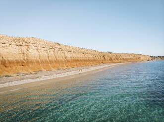 Aerial view of Balgowan beach with orange cliffs and turquoise water and two people standing on the beach, Yorke Peninsula, South Australia. - AAEF23994