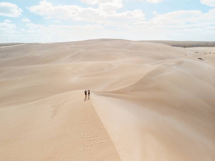 Aerial view of two people standing on a sand dunes in Port Lincoln National Park, South Australia. - AAEF24005