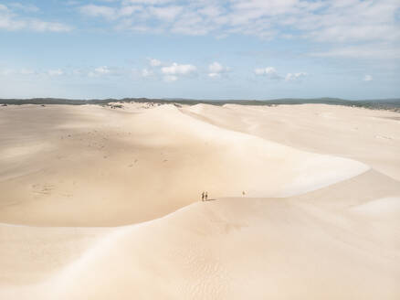 Aerial view of a desert landscape with two people standing on a sand dune in Port Lincoln National Park, South Australia. - AAEF24008
