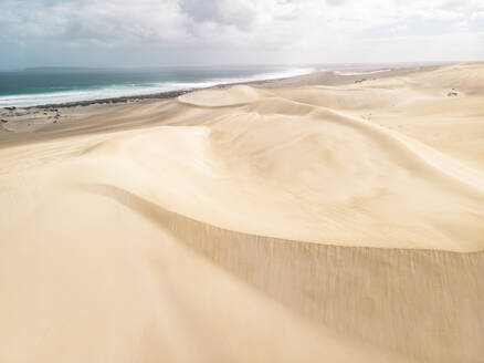 Aerial view of a desert landscape with sand dunes and the ocean in the background, Port Lincoln National Park, South Australia. - AAEF24009