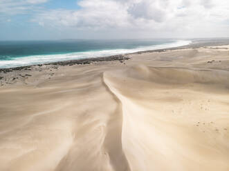 Aerial view of a desert landscape with sand dunes and the ocean in the background, Port Lincoln National Park, South Australia. - AAEF24010