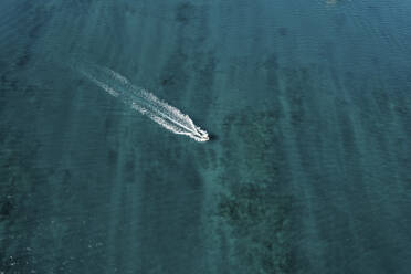 Aerial view of a motorboat driving in clear blue water, Broome, Western Australia. - AAEF24036