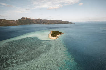 Aerial view of Black Island with the reef stretching far out and Hook Island visible in the distance, Whitsundays, Australia. - AAEF24047