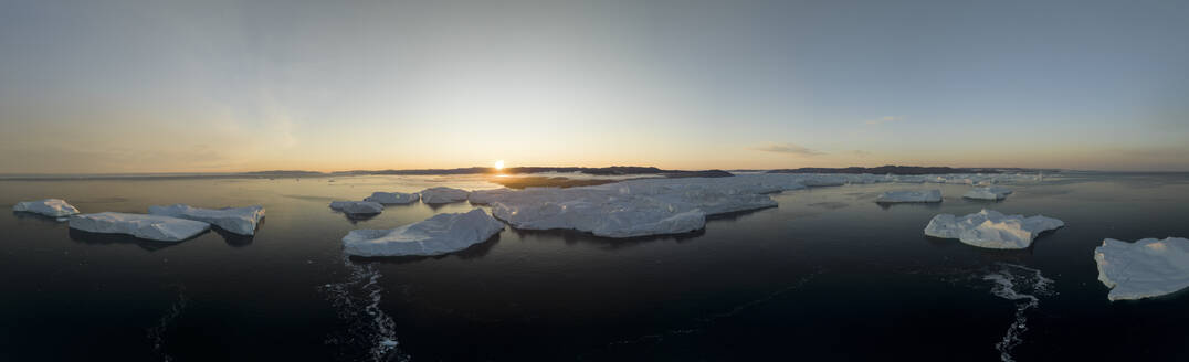 Aerial panoramic drone view of the iceberg glacier fjord at Ilulissat at a golden sunrise, Greenland, Arctic. - AAEF24173