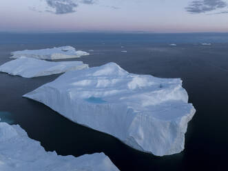 Drohnenaufnahme eines riesigen Eisbergs mit einem See aus geschmolzenem Wasser am Ilulissat-Eisfjord in Grönland, Arktis. - AAEF24195