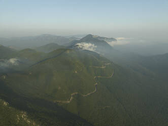 Luftaufnahme einer Straße entlang des Bergkamms auf dem Gipfel des Monte Terminio bei Sonnenuntergang vom Aussichtspunkt Ripe della Falconara, Serino, Kampanien, Avellino, Italien. - AAEF24217