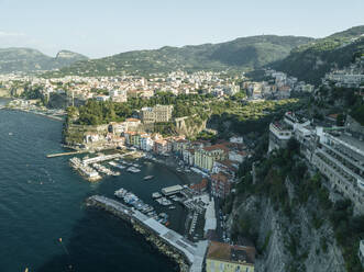 Aerial view of sailing boat along the coast in Sorrento Bay near the harbour, Naples, Campania, Italy. - AAEF24235