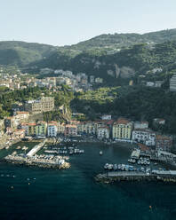 Aerial view of sailing boat along the coast in Sorrento Bay near the harbour, Naples, Campania, Italy. - AAEF24236