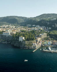 Aerial view of sailing boat along the coast in Sorrento Bay near the harbour, Naples, Campania, Italy. - AAEF24239