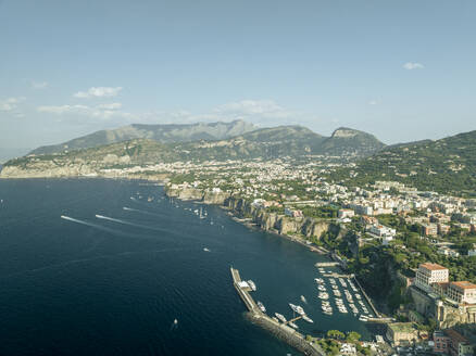 Aerial view of sailing boat along the coast in Sorrento Bay near the harbour, Naples, Campania, Italy. - AAEF24243