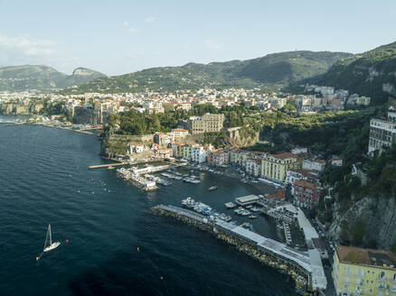 Aerial view of sailing boat along the coast in Sorrento Bay near the harbour, Naples, Campania, Italy. - AAEF24260