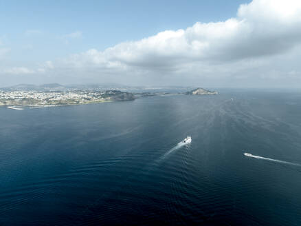 Luftaufnahme einer Fähre, die den Golf von Neapel von der Insel Procida nach Neapel überquert, Blick auf den Monte di Procida und die Landzunge Faro Capo Miseno, Neapel, Kampanien, Italien. - AAEF24305