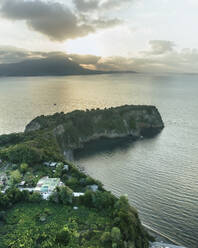 Luftaufnahme von Punta Serra, einer kleinen Landzunge mit hohen Klippen auf der Insel Procida und der Insel Ischia im Hintergrund, Archipel der Flegree-Inseln, Neapel, Kampanien, Italien. - AAEF24335
