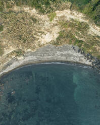 Luftaufnahme des Strandes Cala del Vecchio Pozzo, einer kleinen Bucht mit hohen Klippen auf der Insel Procida bei Sonnenuntergang, Archipel der Flegree-Inseln, Neapel, Kampanien, Italien. - AAEF24339