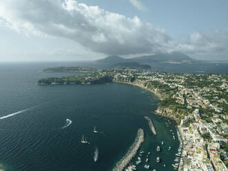 Luftaufnahme der Altstadt von Procida auf der Insel Procida mit der Insel Ischia im Hintergrund, Archipel der Flegree-Inseln, Neapel, Kampanien, Italien. - AAEF24370