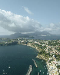 Luftaufnahme der Altstadt von Procida auf der Insel Procida mit der Insel Ischia im Hintergrund, Archipel der Flegree-Inseln, Neapel, Kampanien, Italien. - AAEF24371