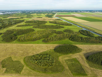 Aerial view of pieces of forest and grassland in the playfully laid out new nature area Bentwoud along cropland, Benthuizen, Zuid-Holland, Netherlands. - AAEF24452