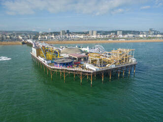 Aerial view of Brighton Palace Pier along the coastline facing the English Channel in Brighton, England, United Kingdom. - AAEF24539