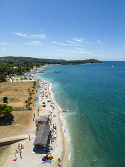 Aerial view of people on the beach relaxing at Hidrobaza park along the coastline near Pula, Istria, Croatia. - AAEF24590