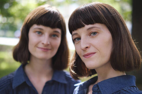 Smiling twin sisters with hair bangs - ASGF04765