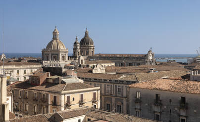 Italien, Sizilien, Catania, Dächer von Wohnhäusern mit Kirchenkuppeln im Hintergrund - FCF02174