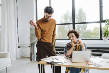 Junge Design-Illustratoren arbeiten gemeinsam am Schreibtisch im Büro - MDOF01638