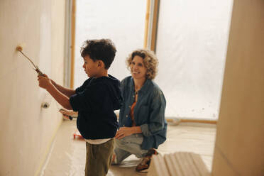 Eine glückliche Mutter und ein glücklicher Sohn renovieren und verschönern gemeinsam das Innere ihres Hauses und zeigen dabei ihre Kreativität und ihr Lächeln. - JLPSF31019