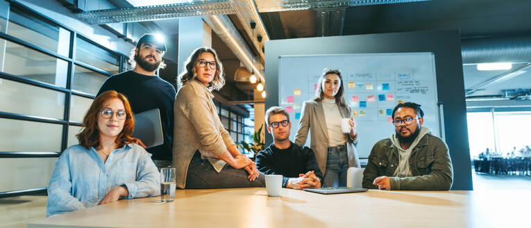 Portrait of a diverse business team in a tech company looking at camera. They display teamwork and dedication. A multicultural team looks confidently at camera emphasizing their commitment to success. - JLPSF31133