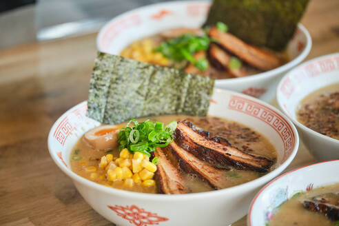 Stockfoto von leckeren Ramen-Suppen mit gekochtem Ei und Fleisch in einem japanischen Restaurant, bereit zum Servieren. - ADSF48860