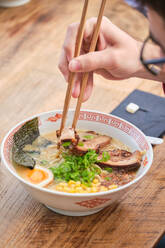 Stock photo of unrecognized person enjoying noodles soup in japanese restaurant. - ADSF48865