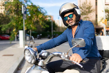 Businessman on a motorbike on a sunny day in the city - ADSF49031