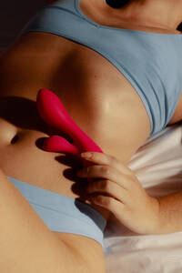 Eine Frau erkundet ihre Sexualität mit einem Spielzeug für Erwachsene. Auf einem Bett liegend, hält sie einen Vibrator in der Hand, erlebt Leidenschaft und sucht Vergnügen. Diese Szene fängt die Essenz der sexuellen Gesundheit und der Selbstbestimmung einer Frau ein. - JLPPF02404