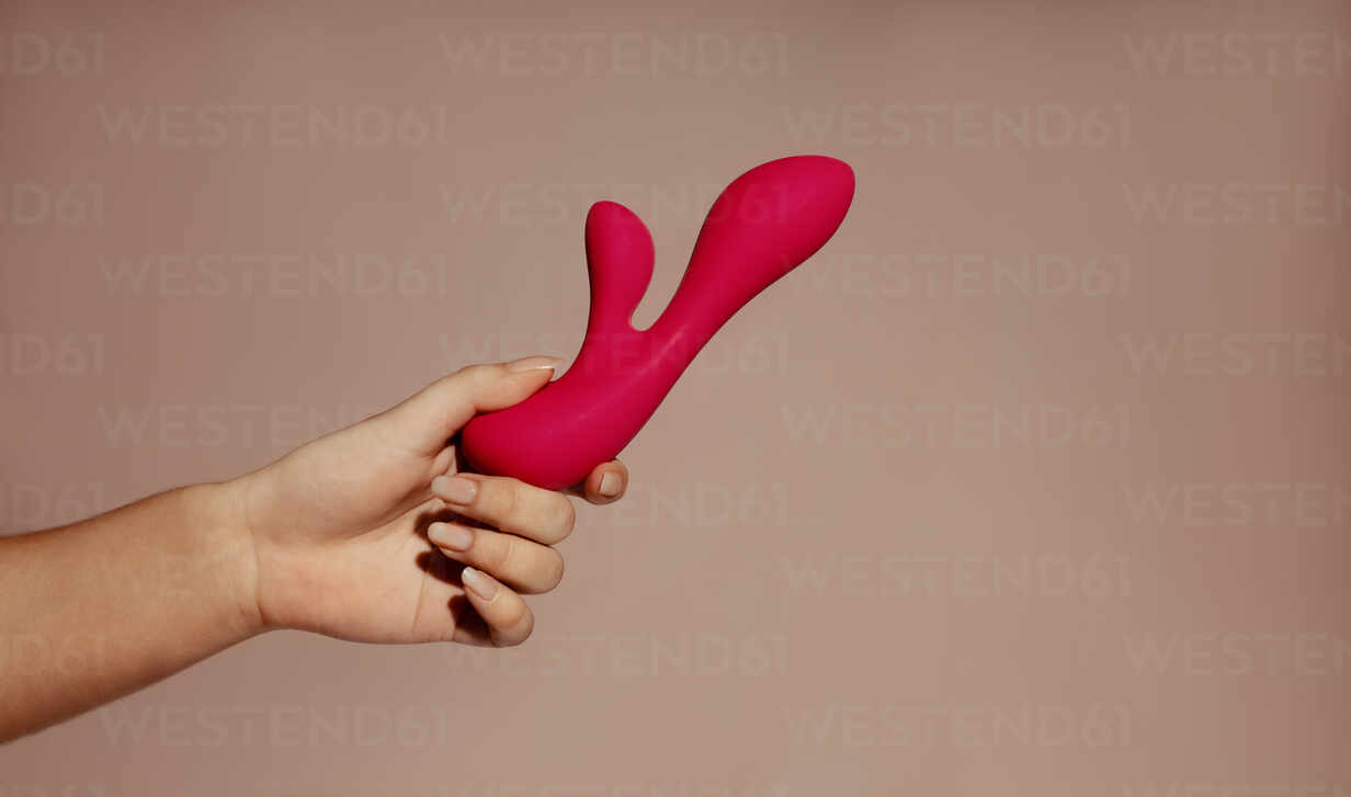 Female hand confidently holds a dual vibrator providing intense