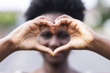 Woman gesturing heart shape with hands - WPEF07804