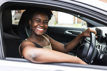 Glückliche Frau im Auto sitzend auf einer Autoreise - WPEF07812