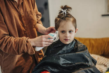 Woman cutting son's hair at home - VSNF01423