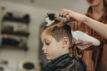 Junge, der von seiner Mutter zu Hause die Haare geschnitten bekommt - VSNF01424