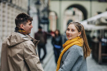 Woman looking over shoulder with boyfriend at street - VSNF01433