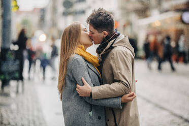 Zärtliches junges Paar, das sich auf der Straße küsst - VSNF01445