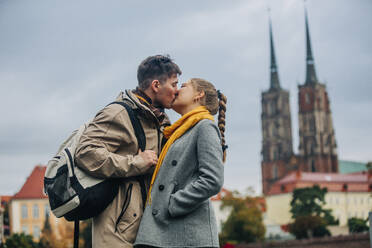Romantic couple kissing in front of building - VSNF01455