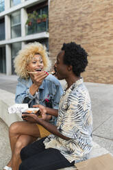 Transgender-Frau füttert ihren Freund auf einer Bank sitzend mit Sushi - VRAF00256