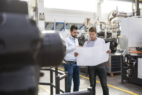 Mitarbeiter diskutieren in der Industrie über den Bauplan - DIGF20986