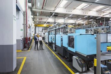 Manager und Mitarbeiter inspizieren Maschinen in der Fabrik - DIGF20999